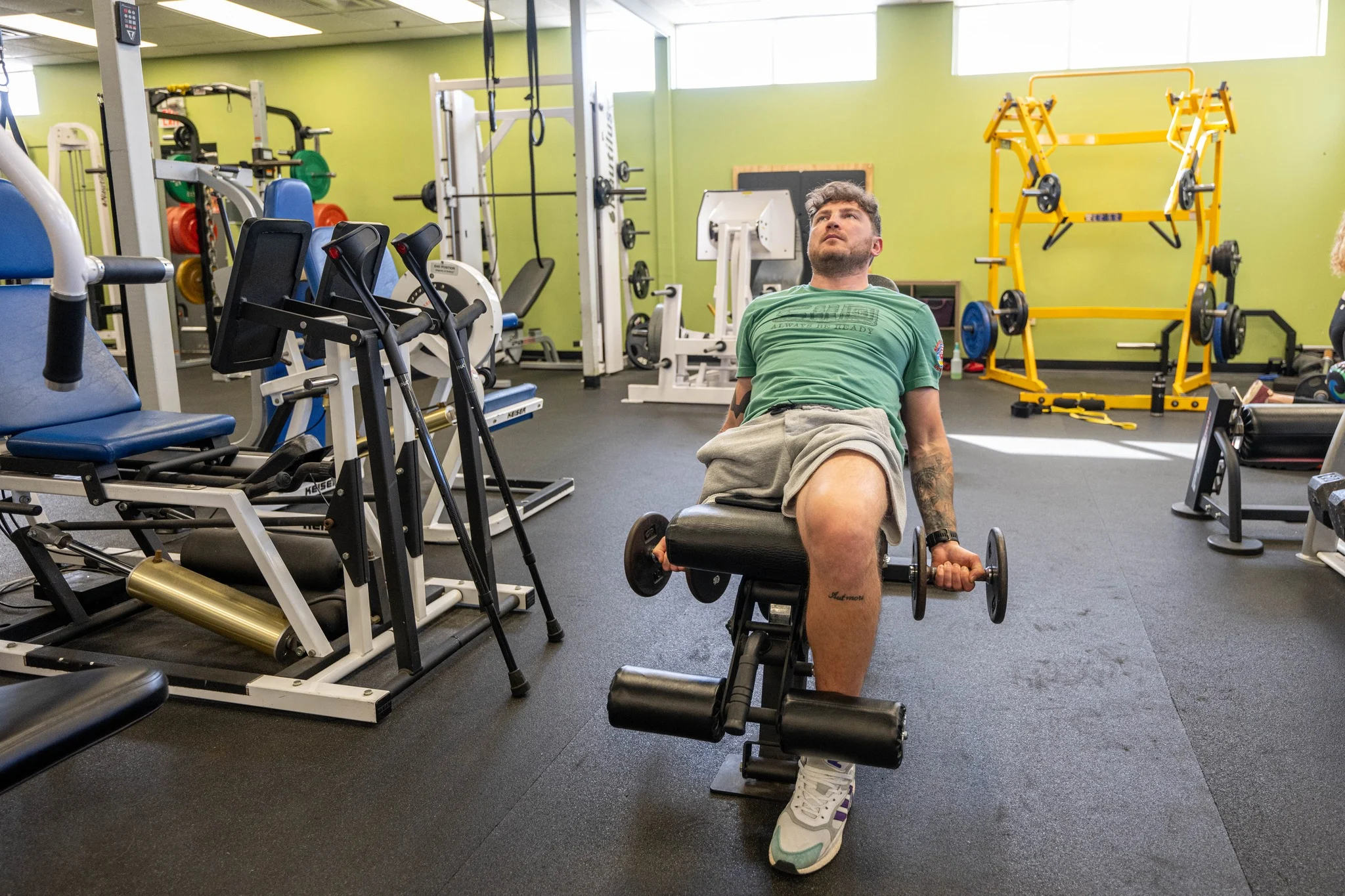 Ein Patient trainiert das Bein an einem Gerät im Rehabilitationsraum